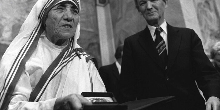 In this Dec. 10, 1979 photo, Mother Teresa receives the Nobel Peace Prize during  a ceremony at Oslo University. At right is the Chairman of the Norwegian Nobel Committee, Professor John Sanness. (Henrik Laurivik/NTB via AP, File)
